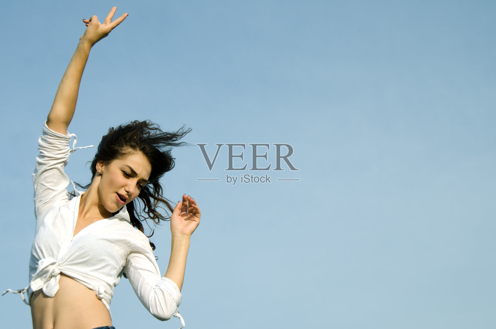 快乐兴奋的年轻女子显示出胜利的迹象。照片摄影图片