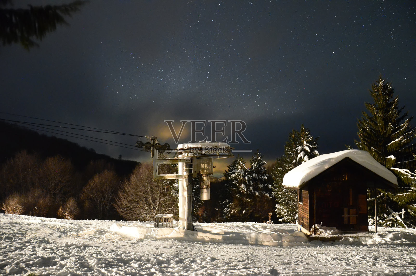 冬季滑雪坡上的房子在黑暗的星空和雪照片摄影图片