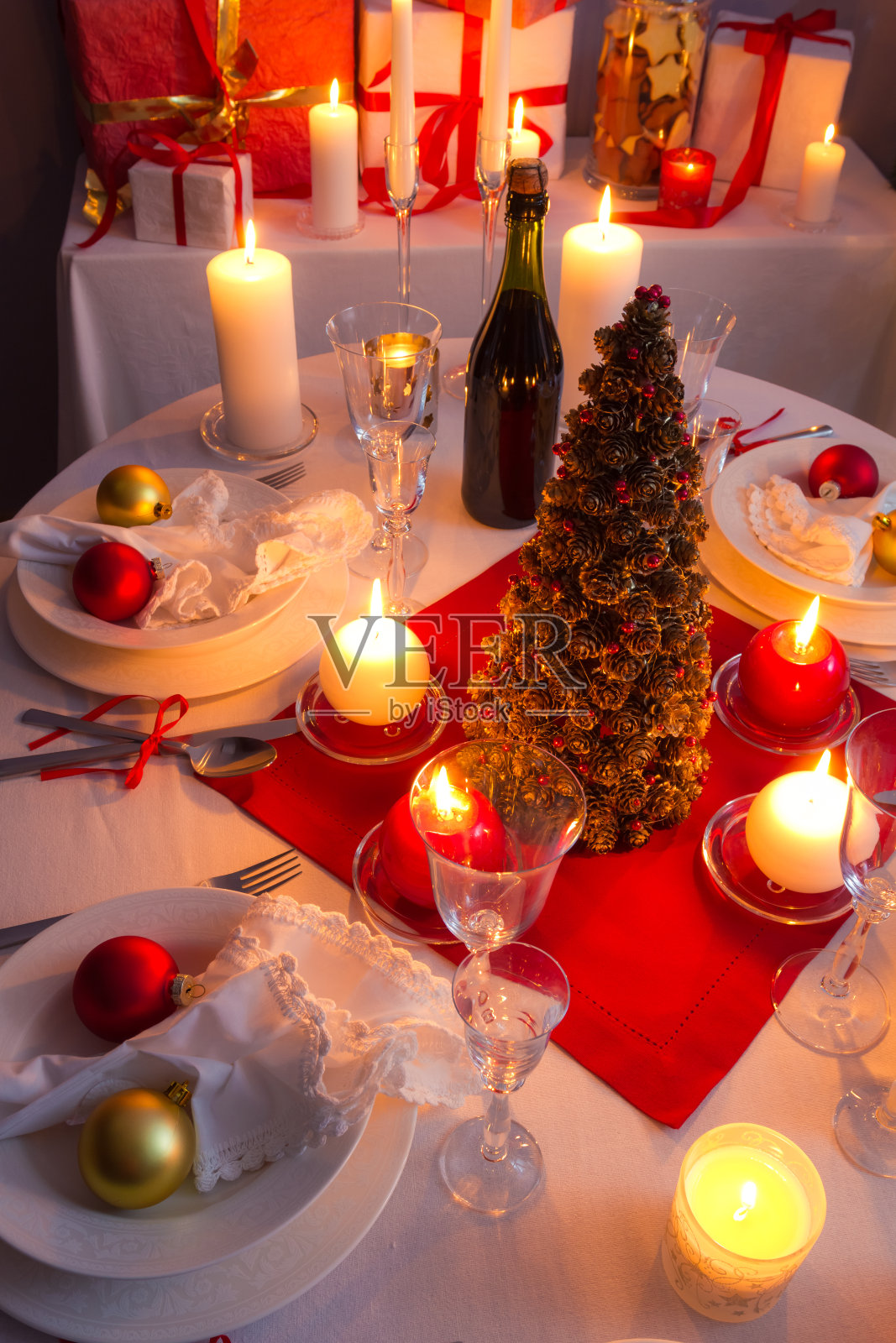 许多礼物在圣诞树旁的烛光里照片摄影图片