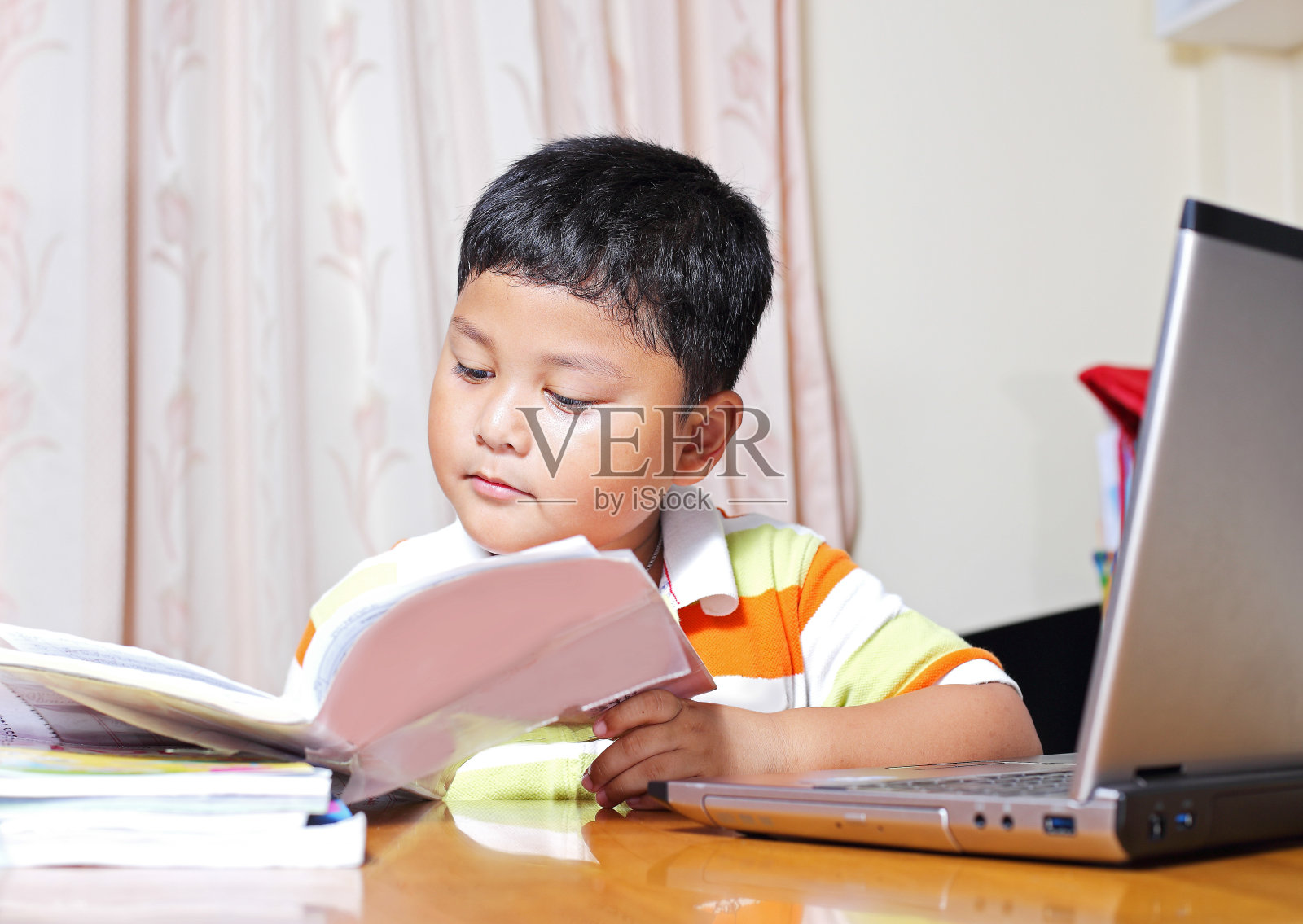 亚洲男孩做作业很认真。照片摄影图片