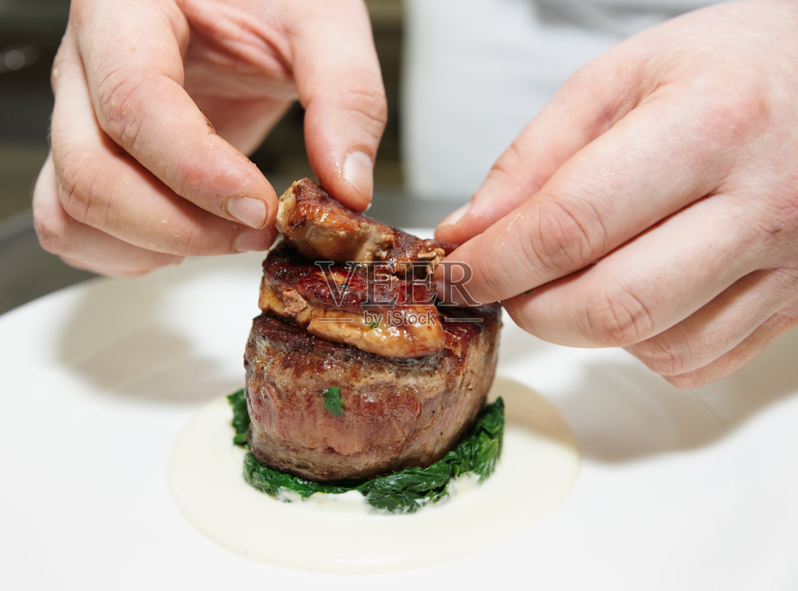 厨师在牛排上加鹅肝酱照片摄影图片