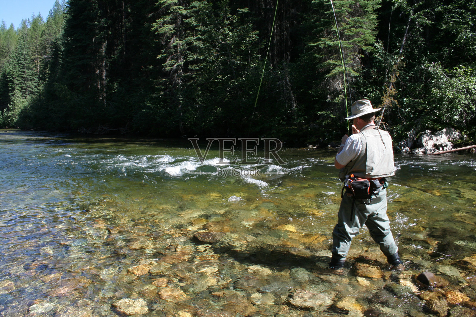 一个人在稳定的河里钓鱼照片摄影图片