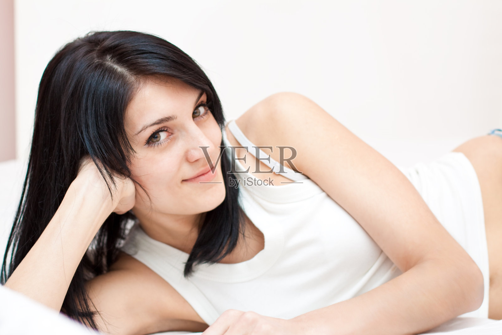 卧室床上温柔微笑的女人照片摄影图片