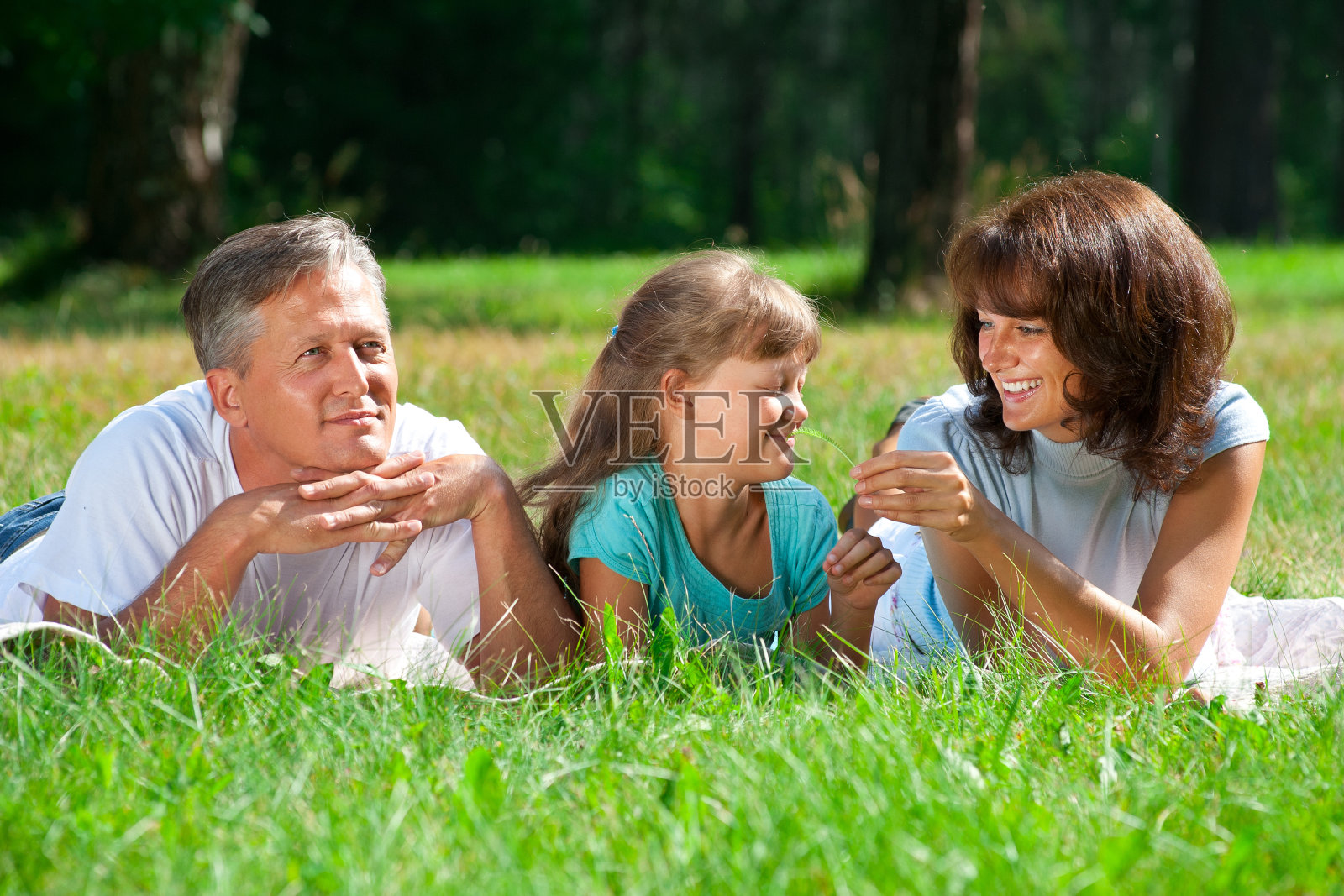 一家人躺在草地上照片摄影图片