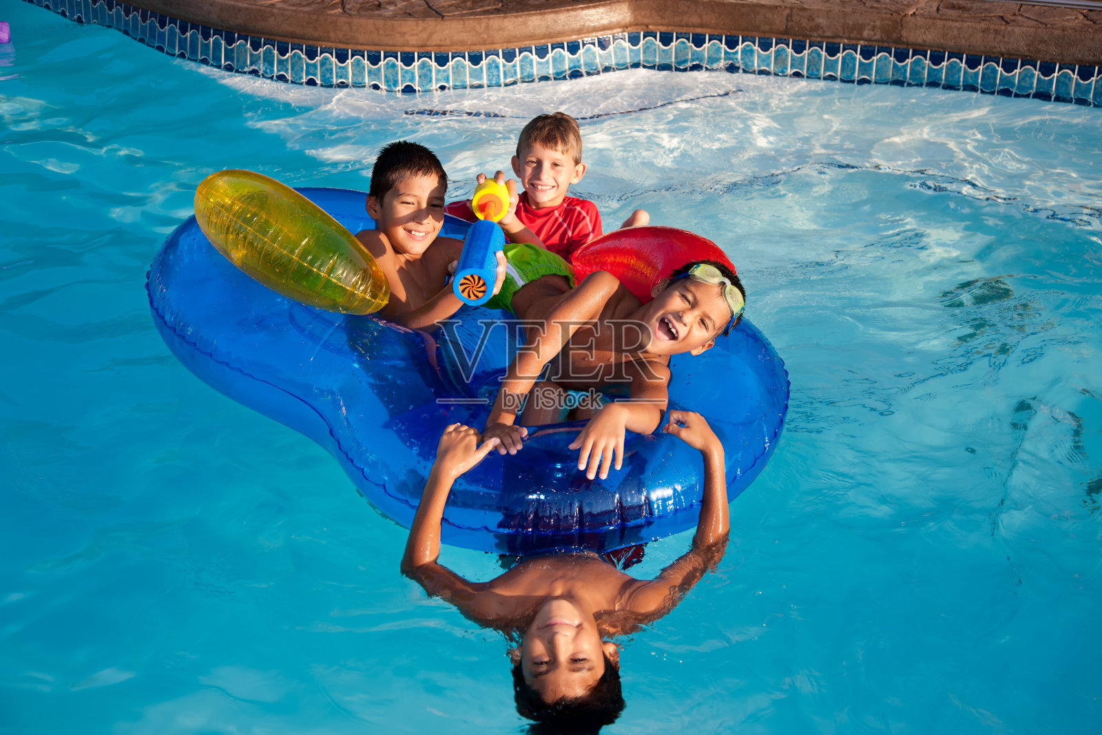 夏季游泳:一群小男孩在室外水池里嬉戏照片摄影图片