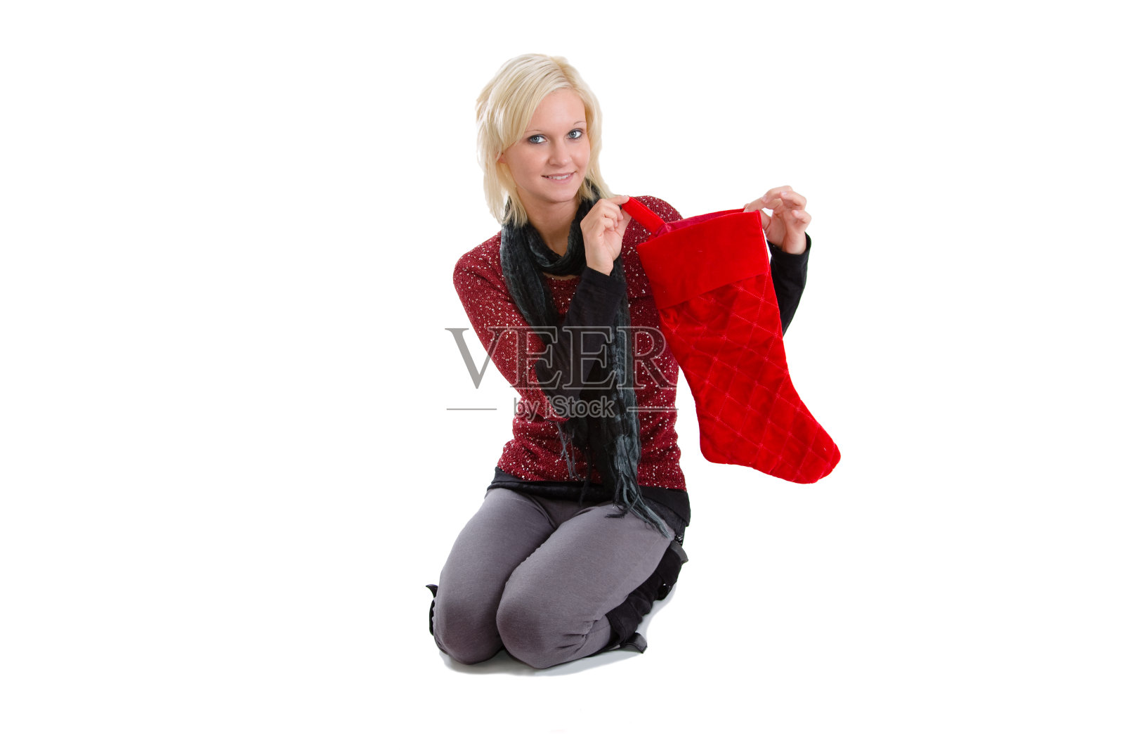 女人跪着,拿着圣诞袜照片摄影图片