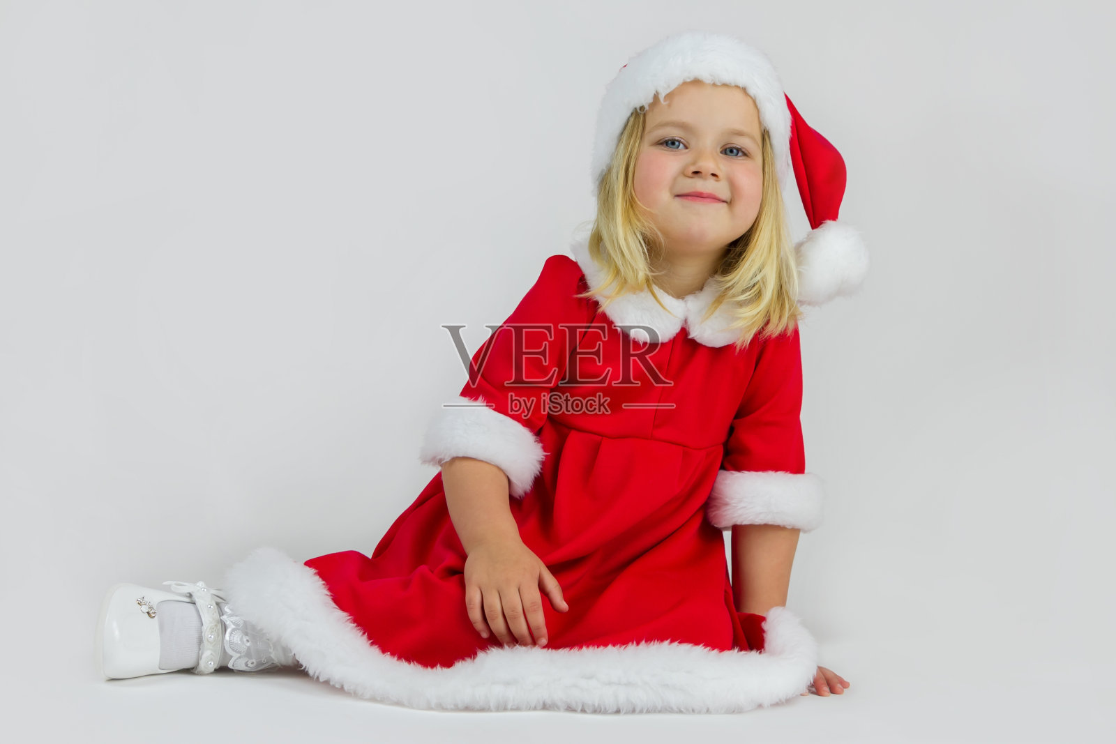 快乐的女孩戴着红色的新年帽照片摄影图片