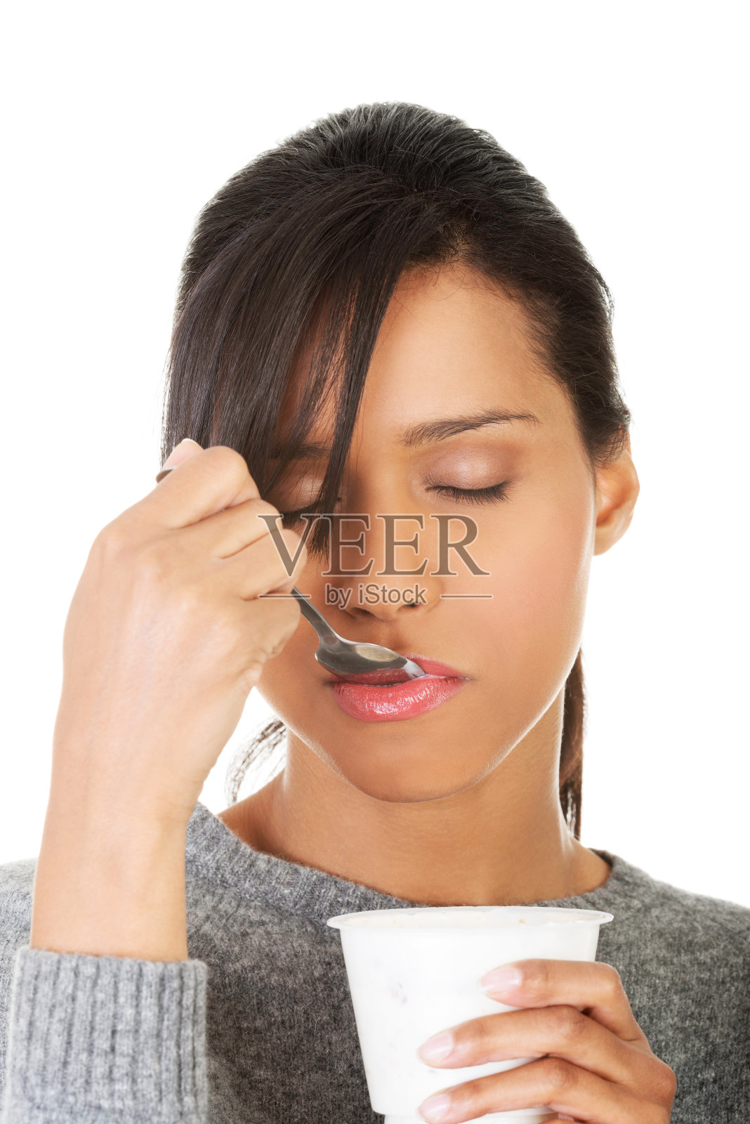 年轻女性吃酸奶作为健康的早餐或零食。照片摄影图片