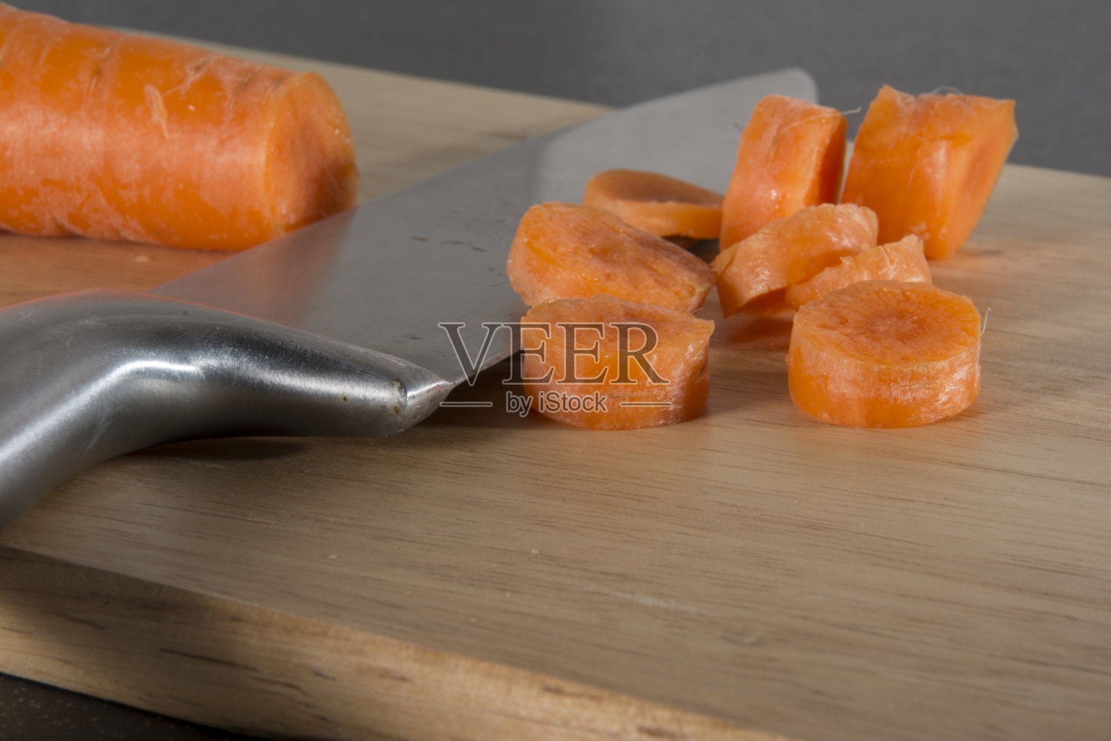 用刀把胡萝卜剁碎放在砧板上照片摄影图片