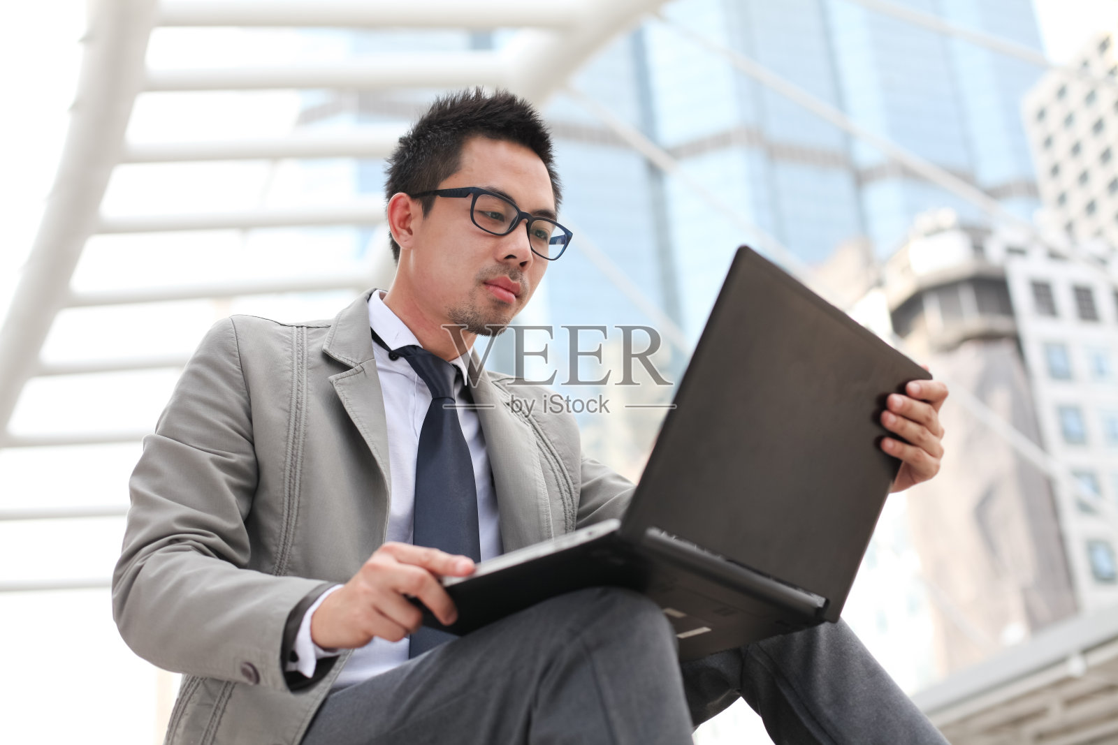 亚洲商人在户外使用笔记本电脑照片摄影图片