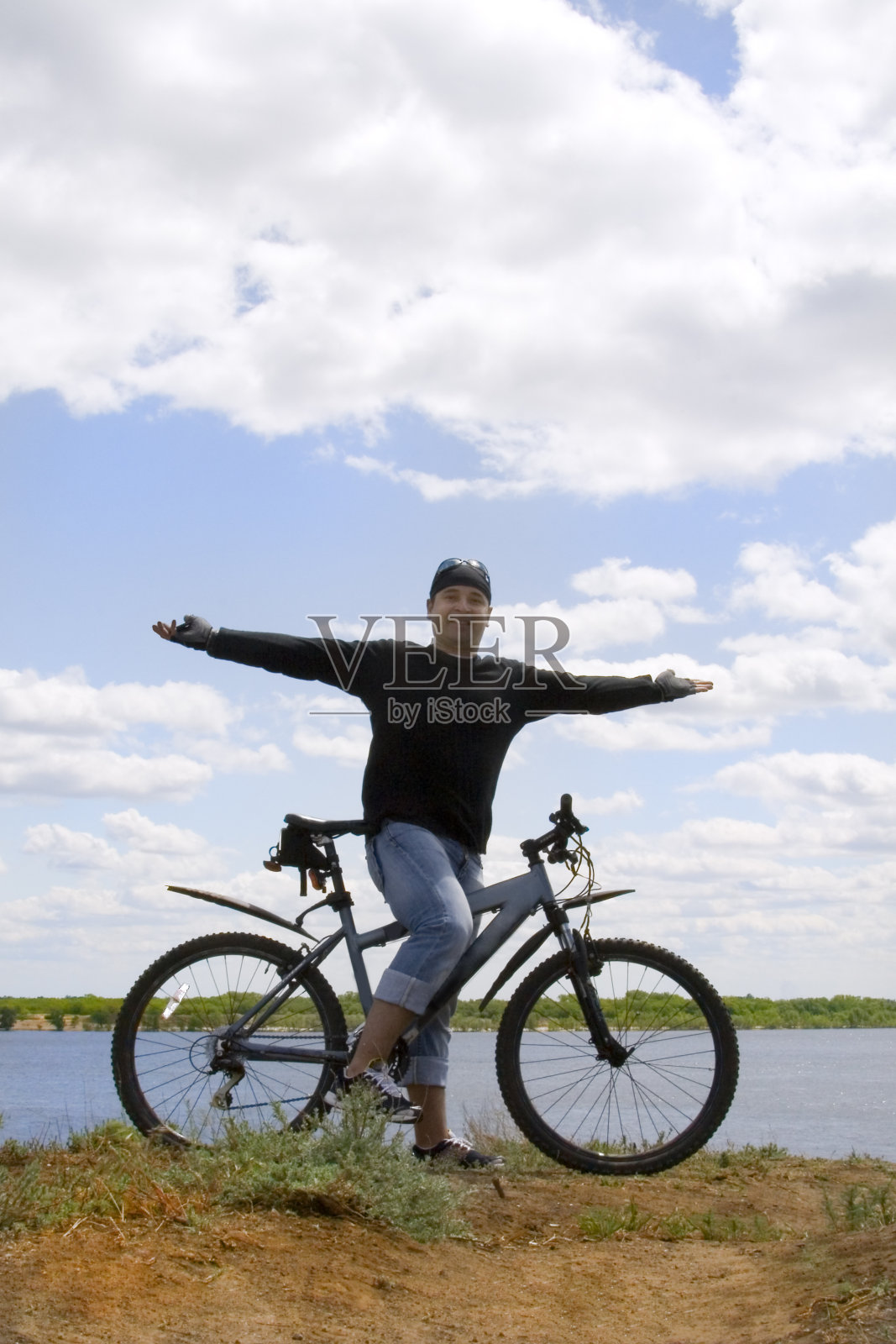 快乐的摩托车手站在乌云密布的天空照片摄影图片