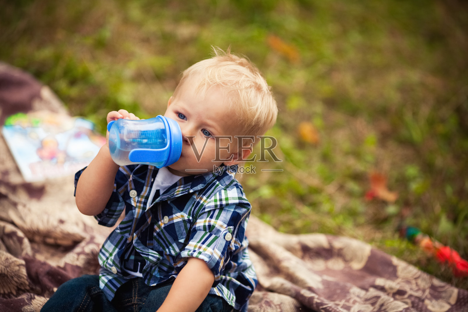 小男孩用瓶子吃饭照片摄影图片