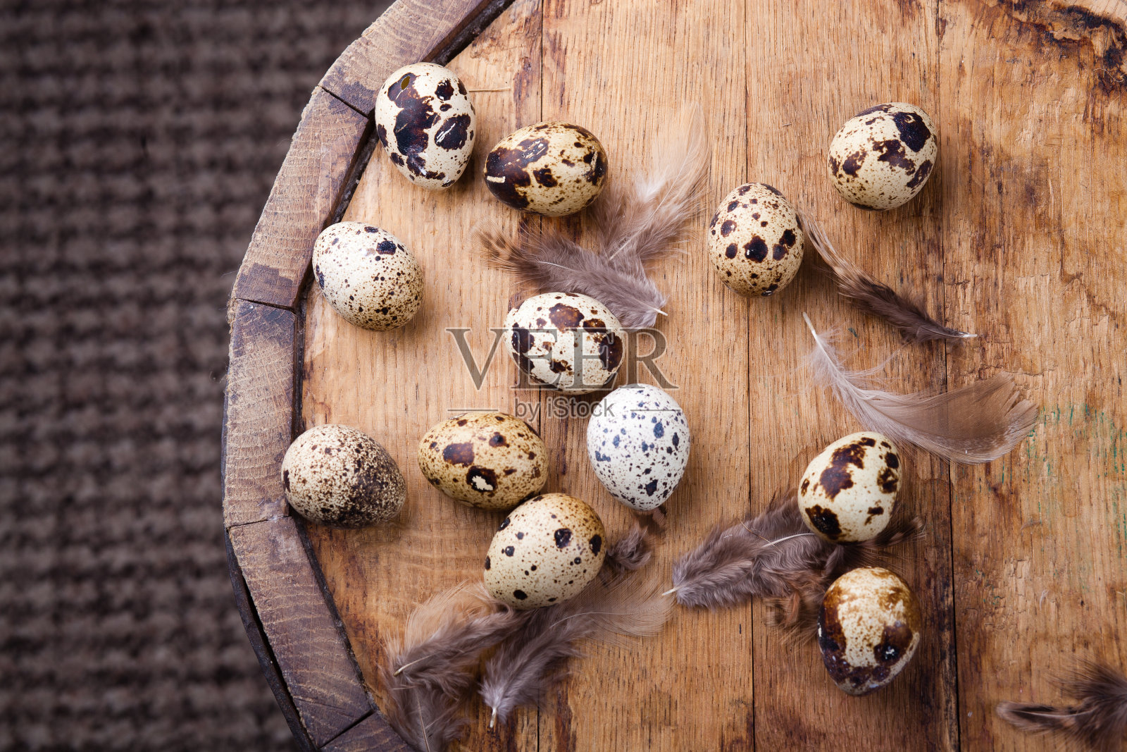 鹌鹑蛋和羽毛放在古老的木桌上照片摄影图片