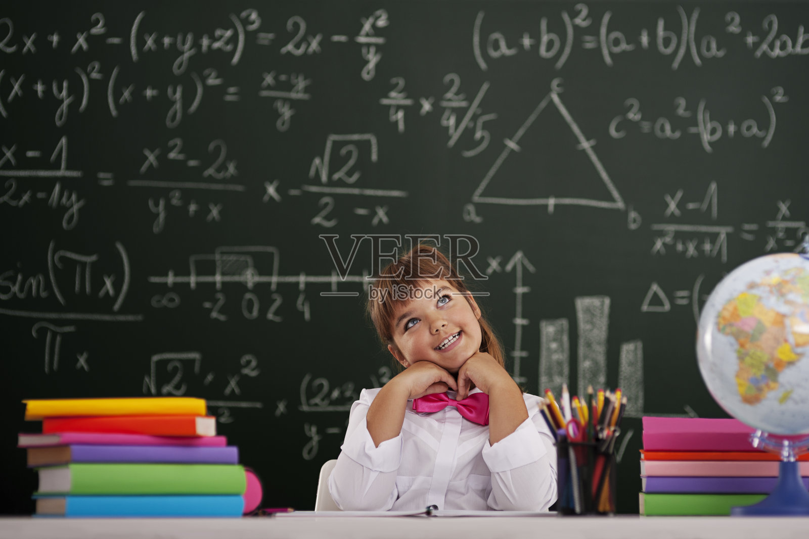 快乐的女孩坐在教室里做梦照片摄影图片