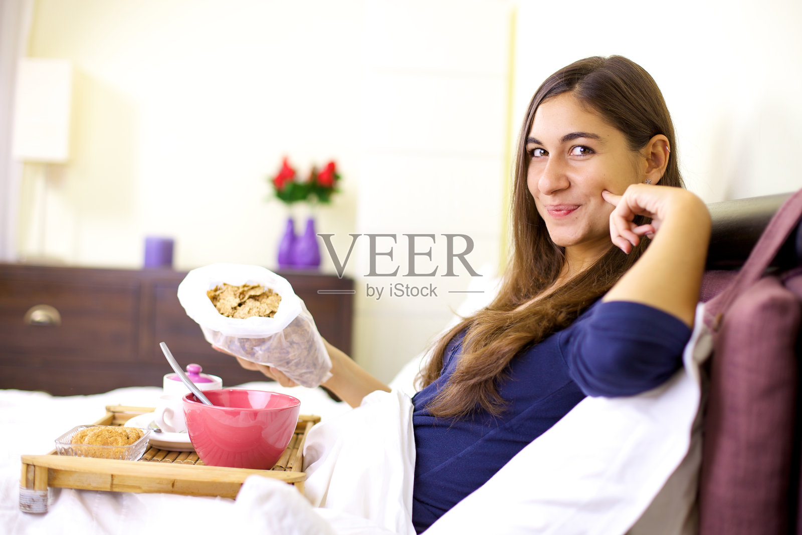 快乐可爱的女孩在床上吃早餐照片摄影图片