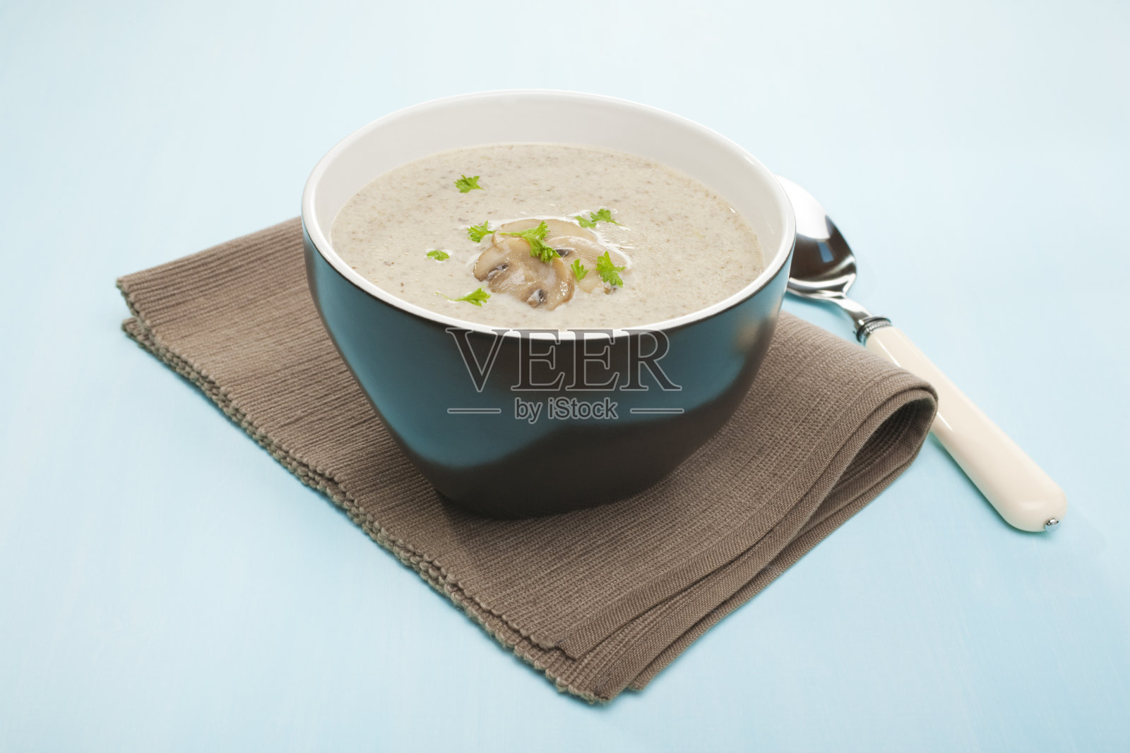 蓝底黑碗蘑菇汤照片摄影图片