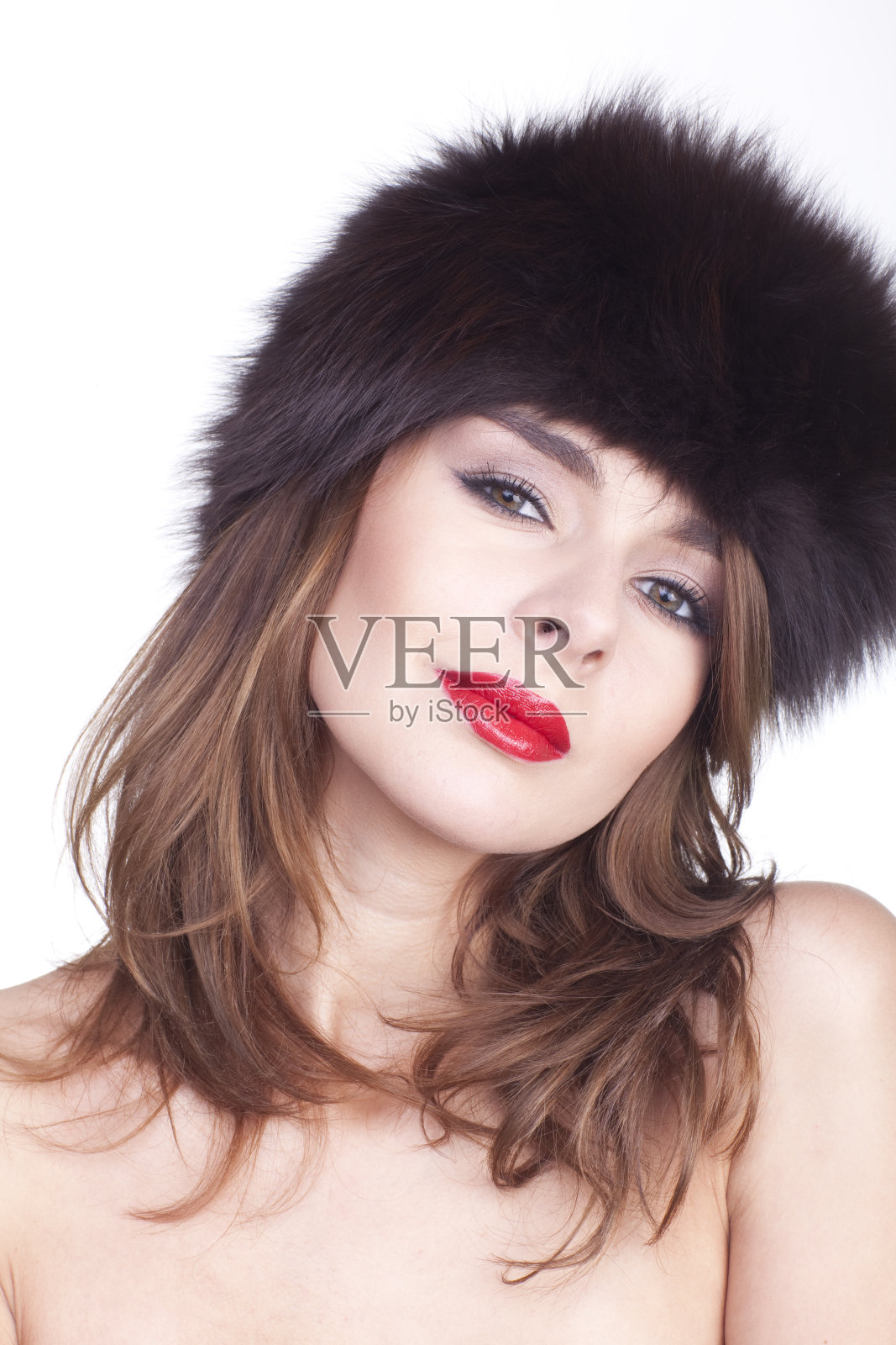 性感的女孩摆姿势在帽子的毛皮。照片摄影图片