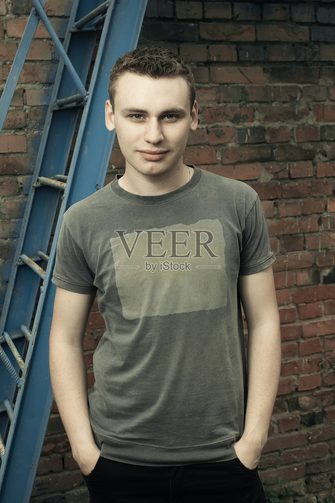 年轻人站在他的手在口袋垃圾背景照片摄影图片