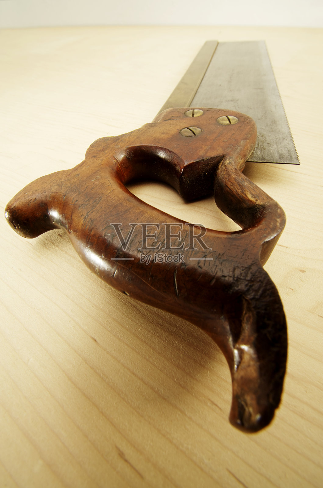 在枫木表面上的旧黄铜背榫锯照片摄影图片