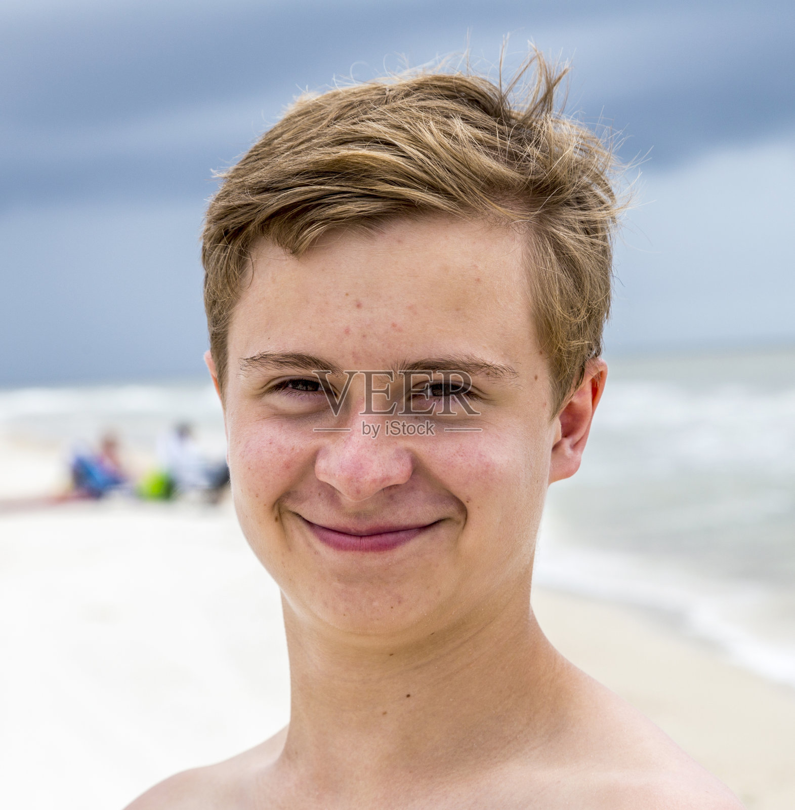 年轻快乐的男孩在海滩上看起来很帅照片摄影图片