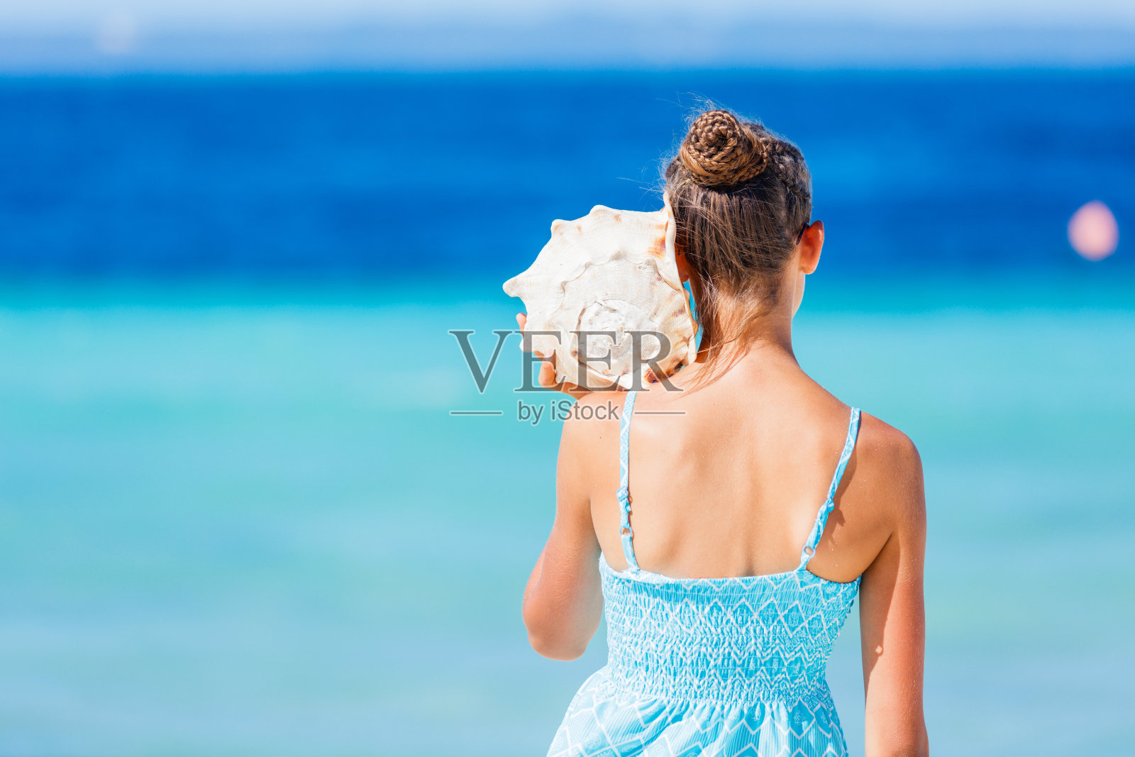 在海滩上拿着贝壳的女孩照片摄影图片