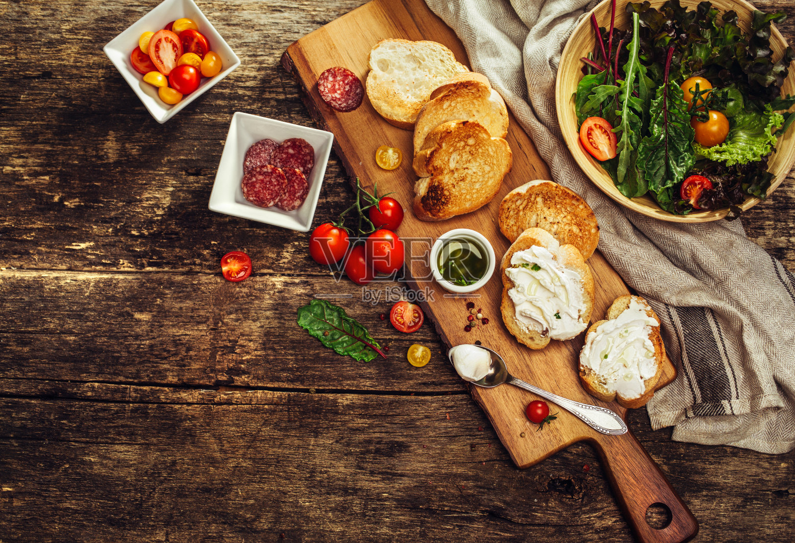 意式烤面包配软奶酪、番茄、香肠和香草。照片摄影图片