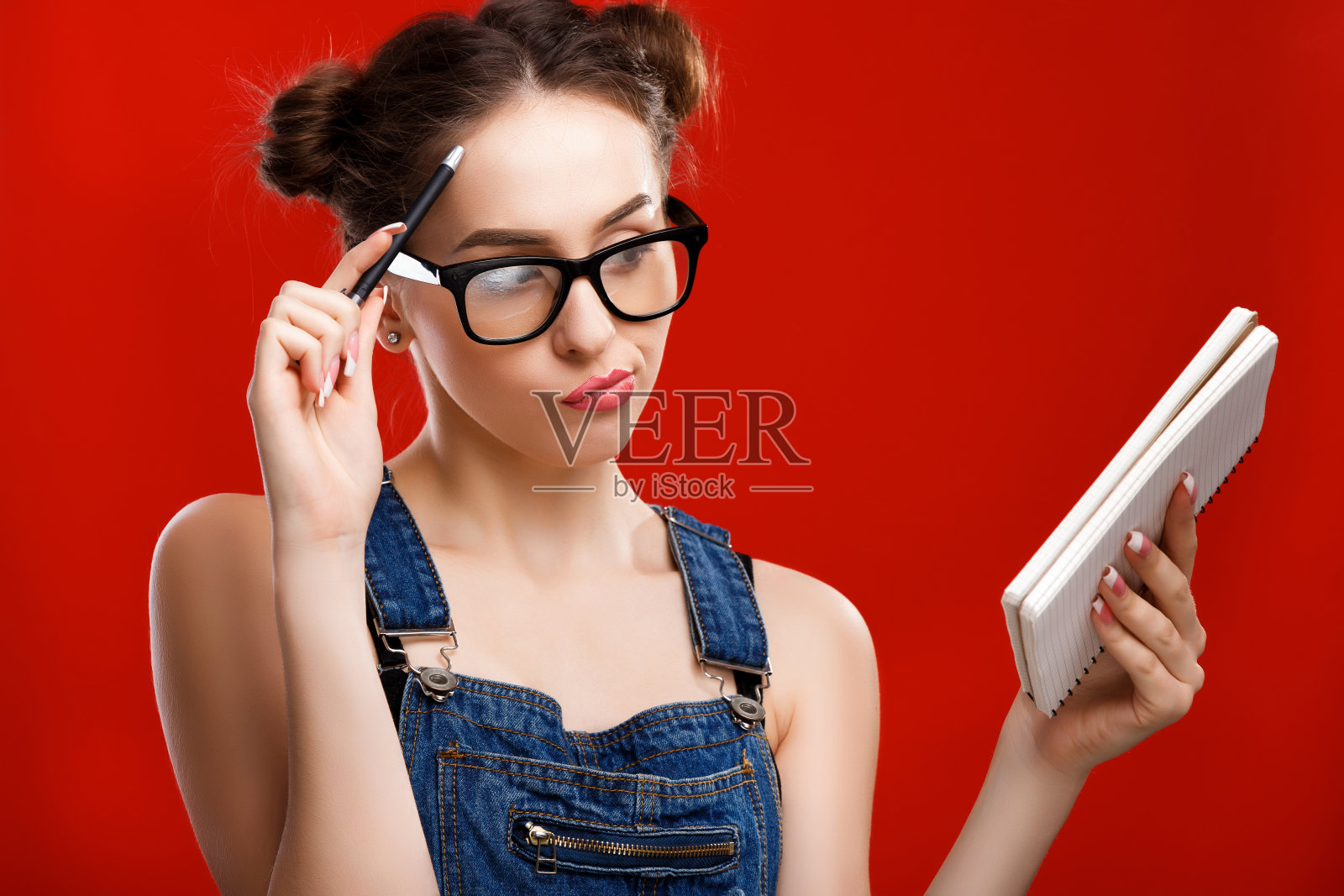 漂亮的女人,手里拿着笔记本和笔照片摄影图片