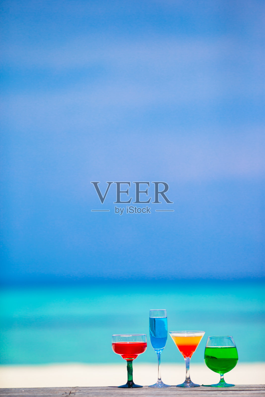 四款五彩缤纷的异国美味鸡尾酒背景绿松石海照片摄影图片