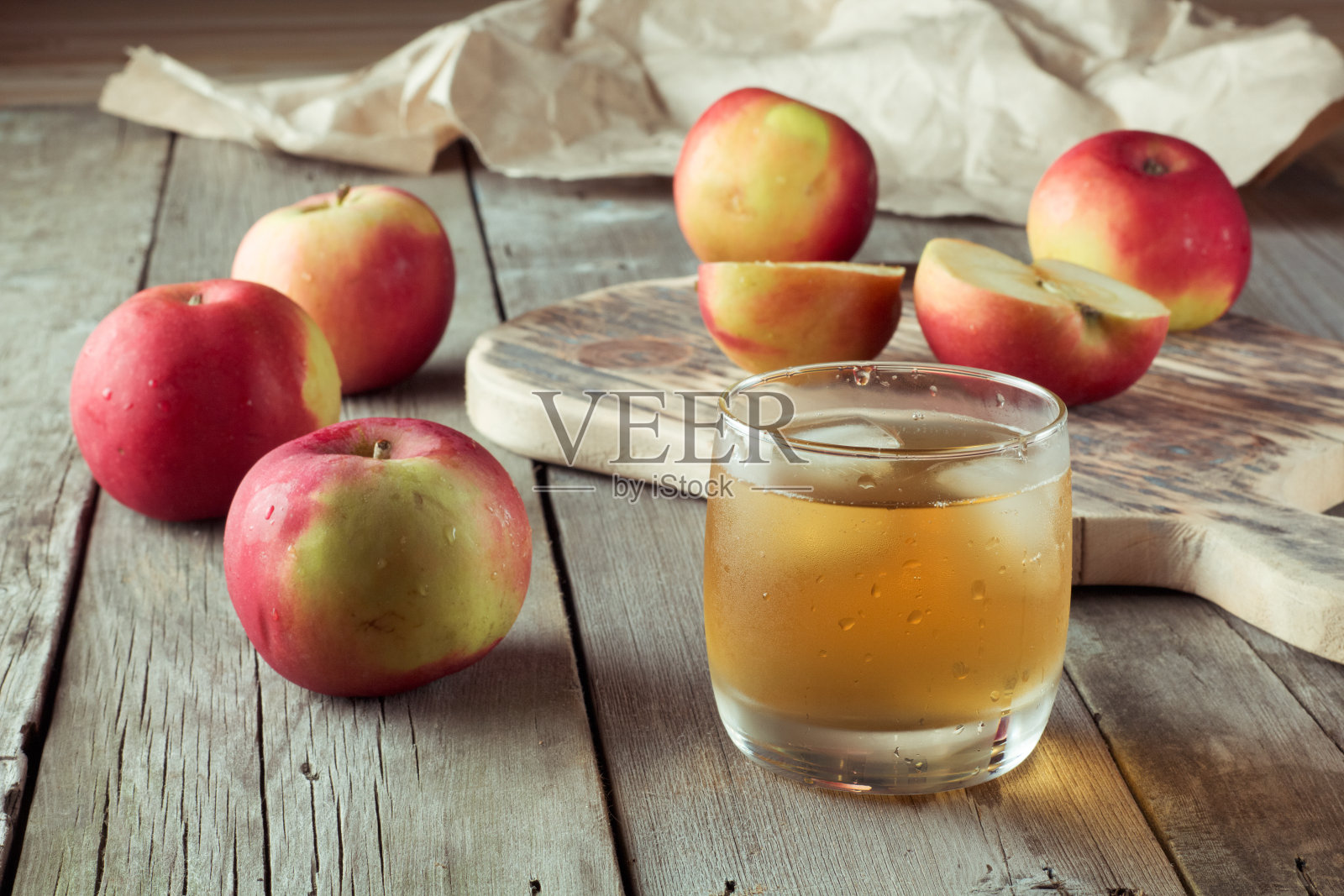 切菜板上放着一杯果汁和苹果照片摄影图片