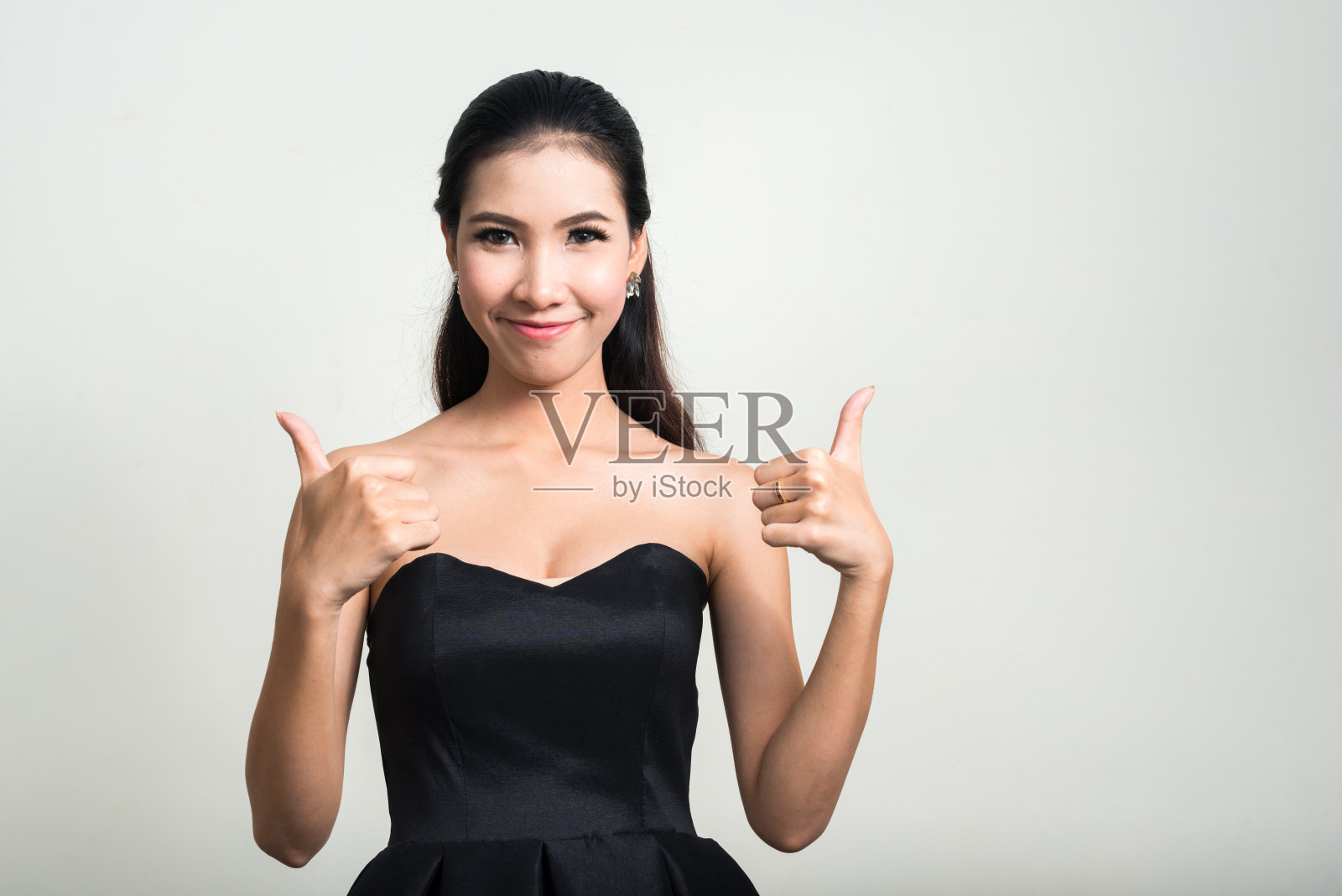 美丽的亚洲女人竖起大拇指的肖像照片摄影图片