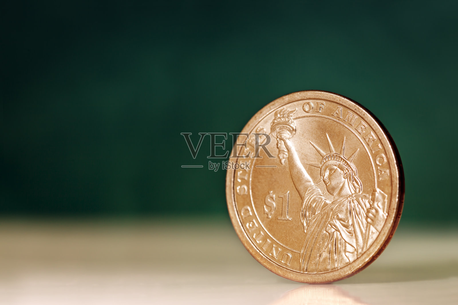 绿色背景上的一美元硬币照片摄影图片