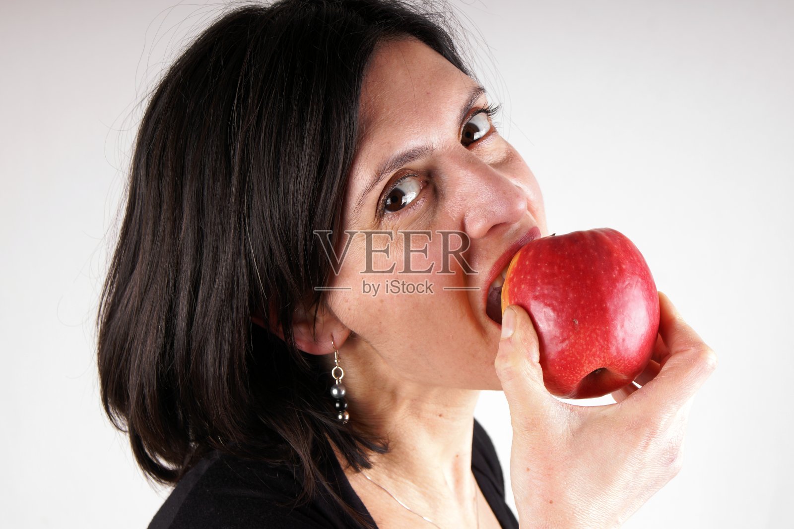 一个穿着黑衣服拿着苹果的女人的肖像照片摄影图片