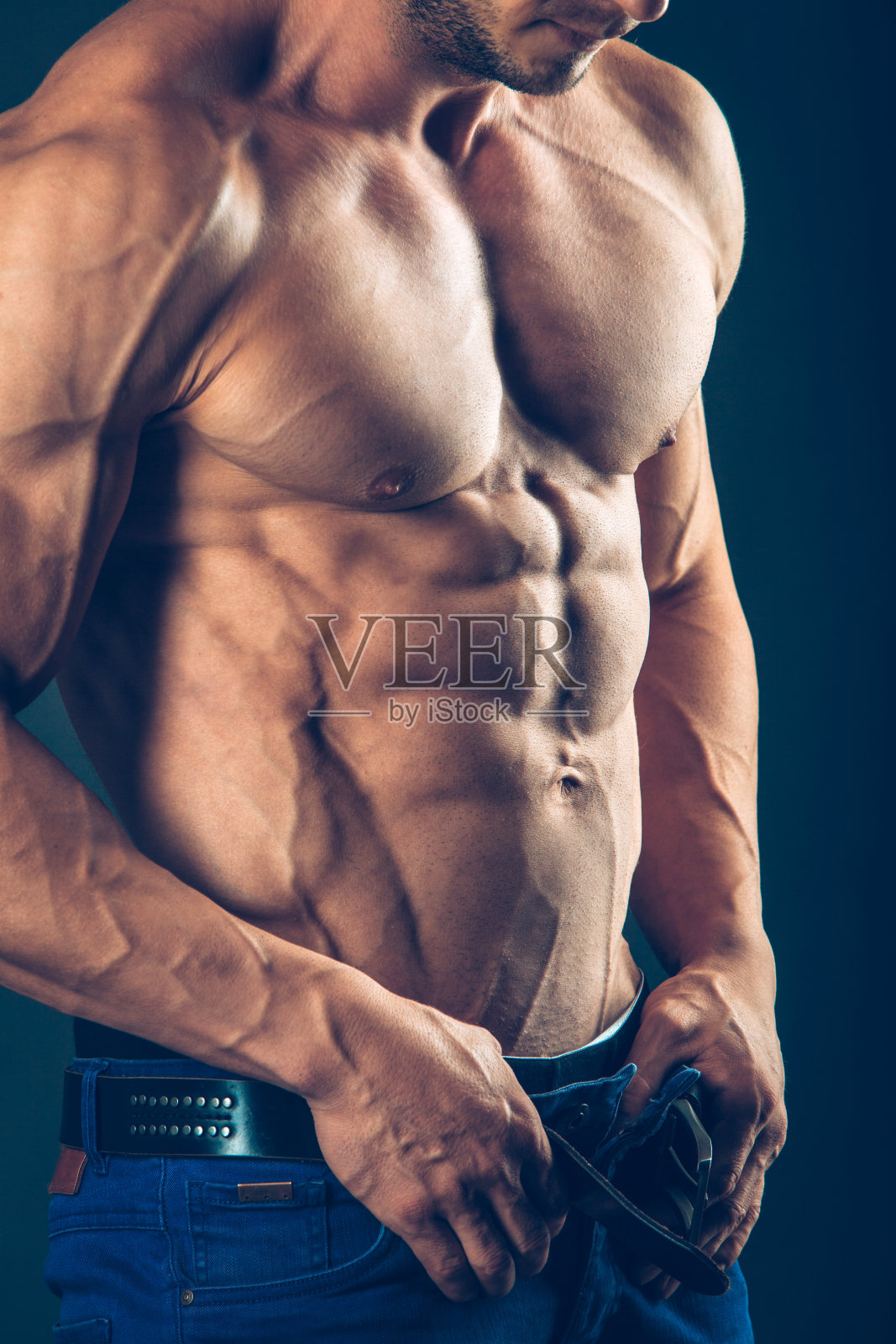 强壮的运动员在黑色背景。泵出腹部照片摄影图片