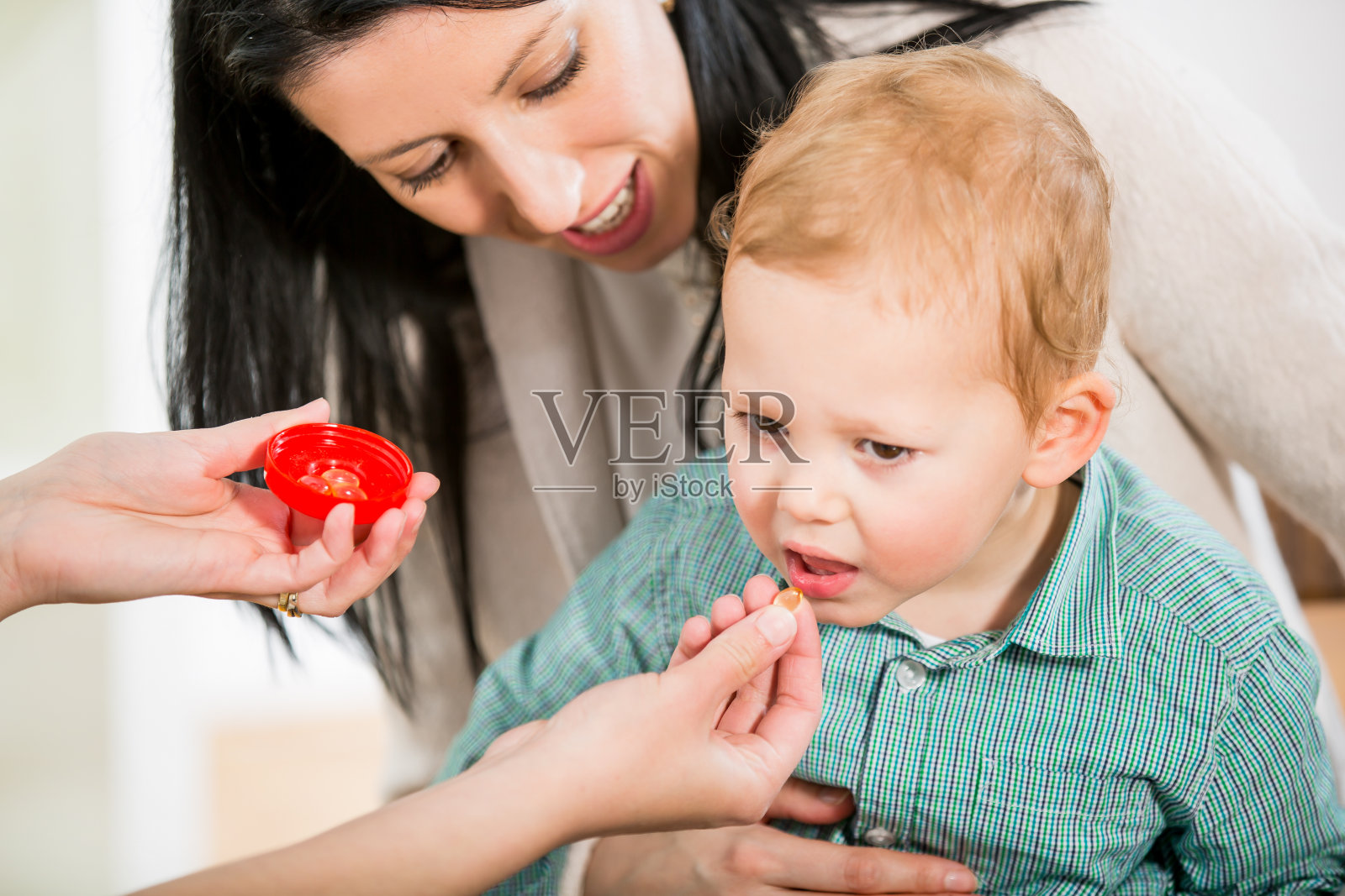 年轻妇女和她的儿子在医生的顺势疗法。照片摄影图片