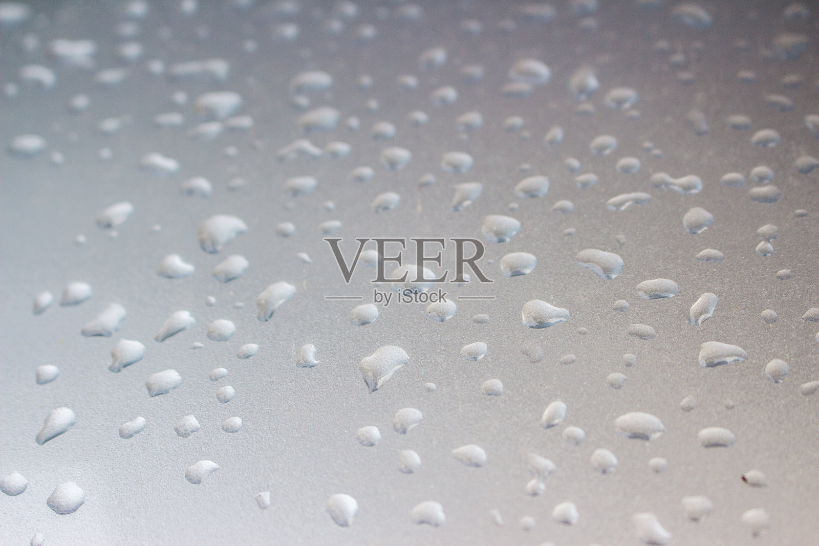 灰色金属背景上的水滴。照片摄影图片