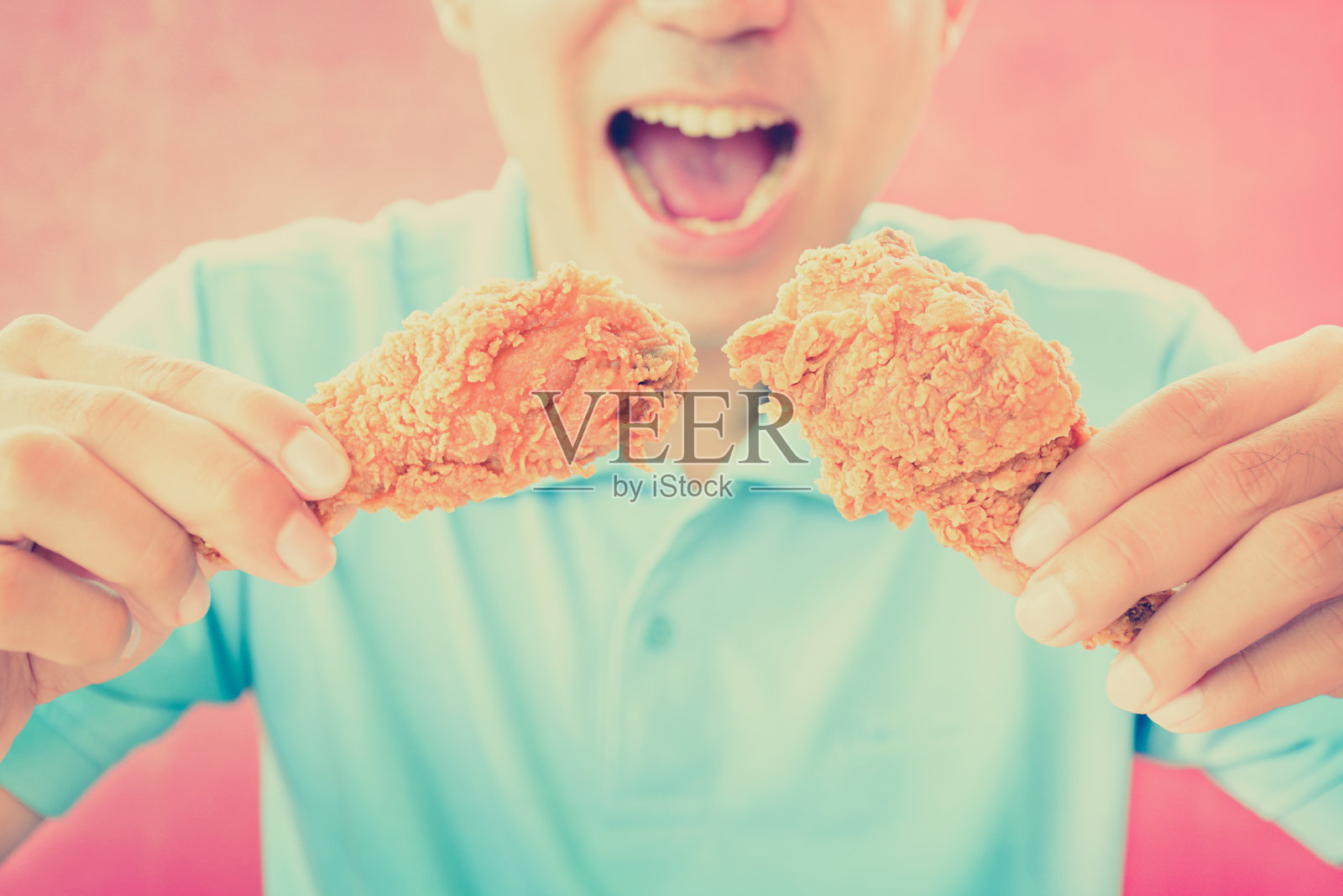 吃油炸鸡腿或鸡腿的年轻人照片摄影图片