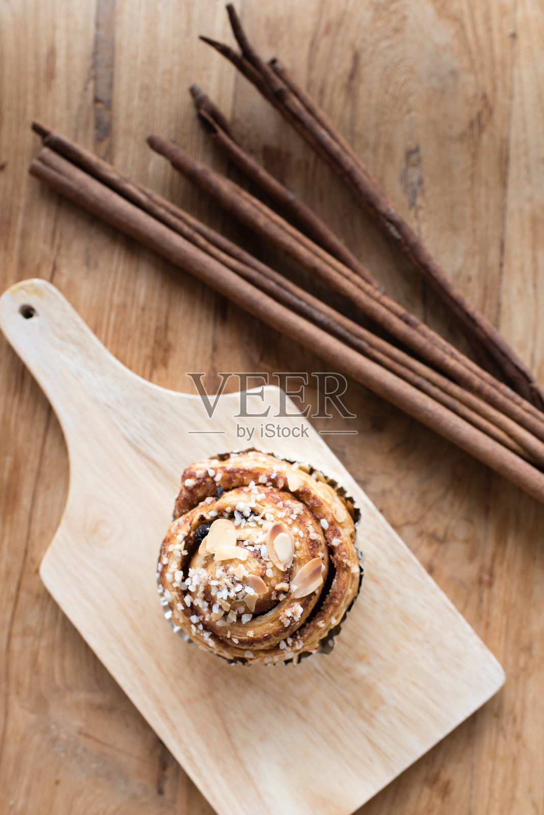 肉桂卷和肉桂棒在木盘子上照片摄影图片