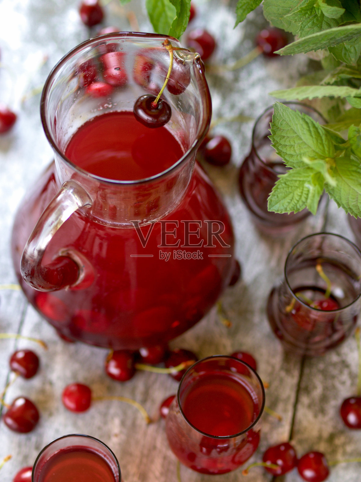 木背景上放着一个玻璃杯,里面放着一盘樱桃照片摄影图片