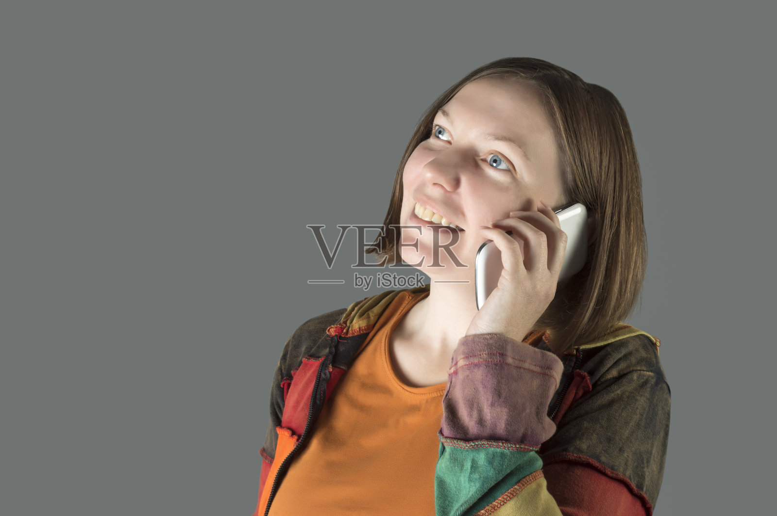 一个女人在用智能手机跟人聊天。照片摄影图片