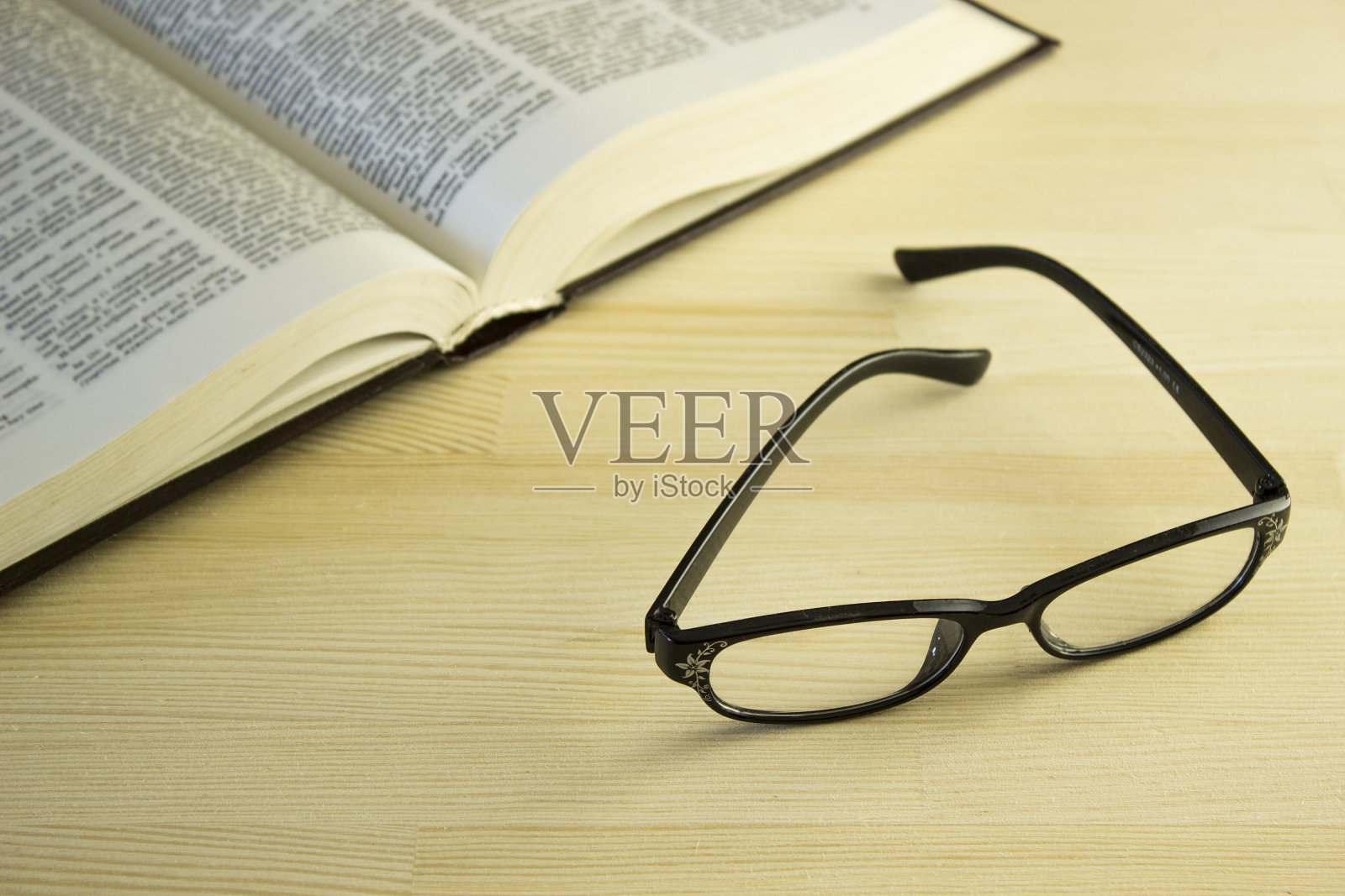 书和眼镜放在一张木桌上照片摄影图片