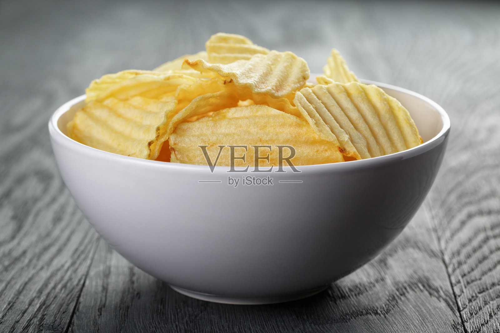 木桌上的白碗里有波纹的有机薯条照片摄影图片