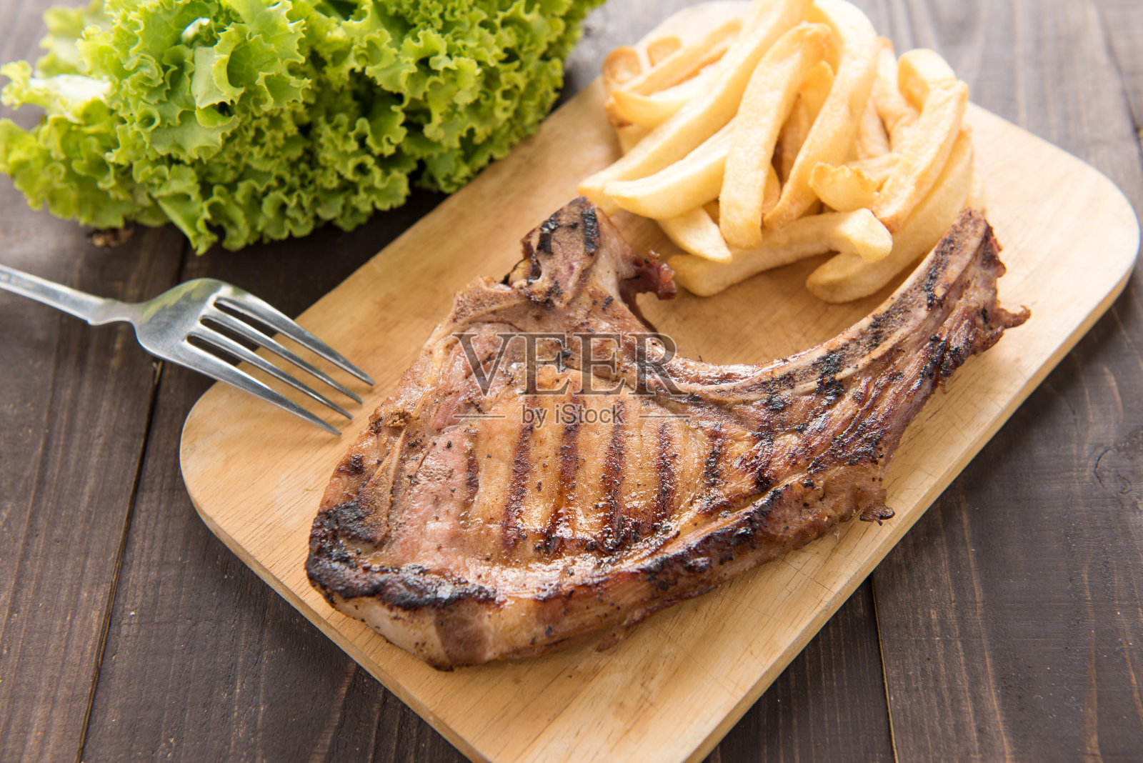 烤牛排和炸薯条放在木板上照片摄影图片
