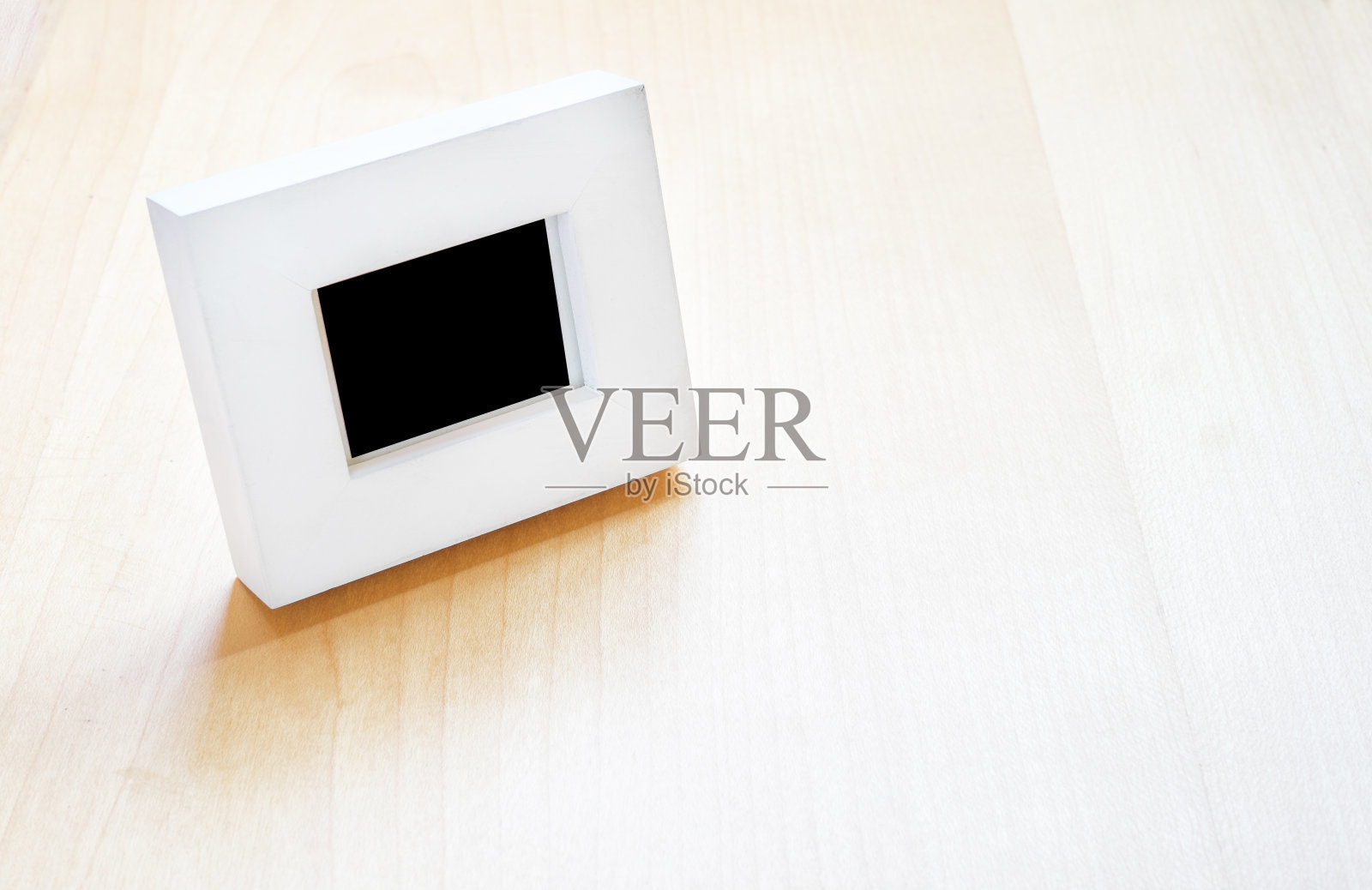 木桌上的白色相框,仿品照片摄影图片