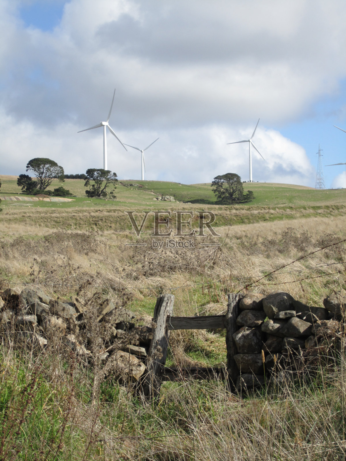 通往风力机的岩石栅栏和大门照片摄影图片