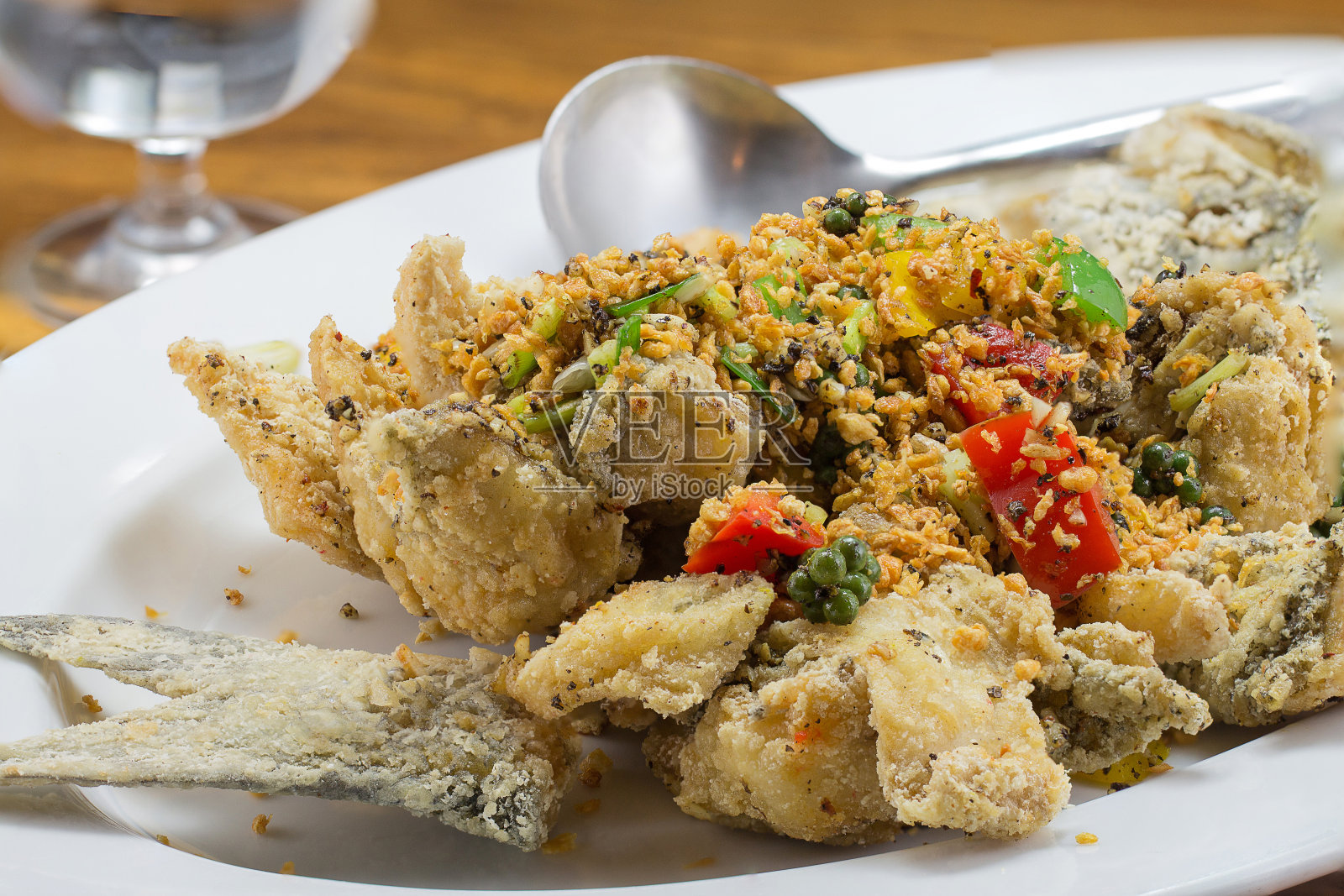 木桌上的白盘子里的烤鱼照片摄影图片