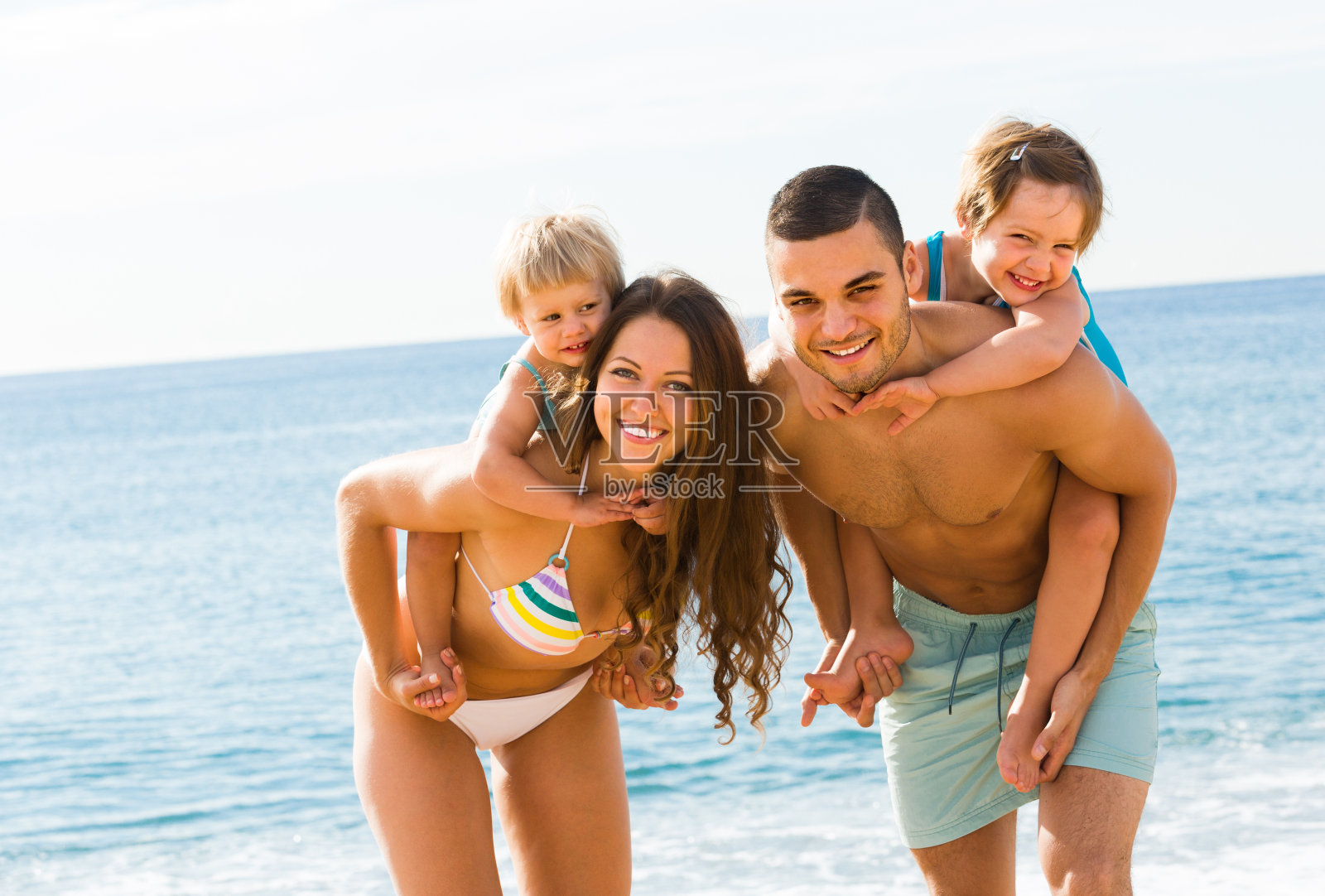 海滩上的一家四口照片摄影图片