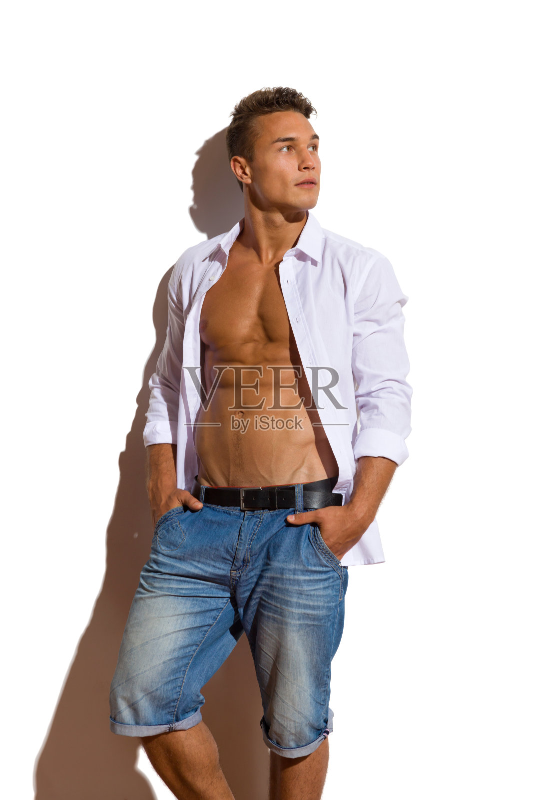 放松英俊的男人在白色解开衬衫看别处照片摄影图片