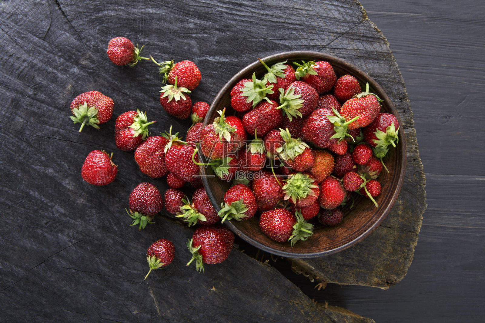 红色的新鲜草莓在黑色的乡村木材背景照片摄影图片