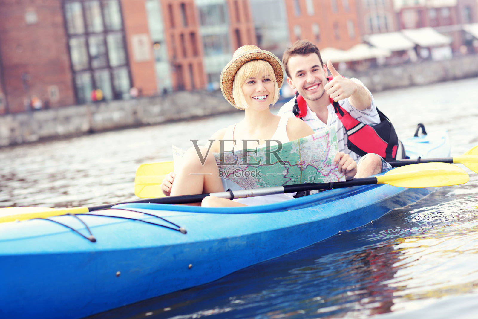 在独木舟里拿着地图的快乐游客照片摄影图片