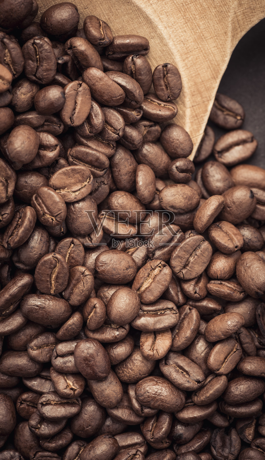 近距离观察木勺上的深色咖啡豆照片摄影图片